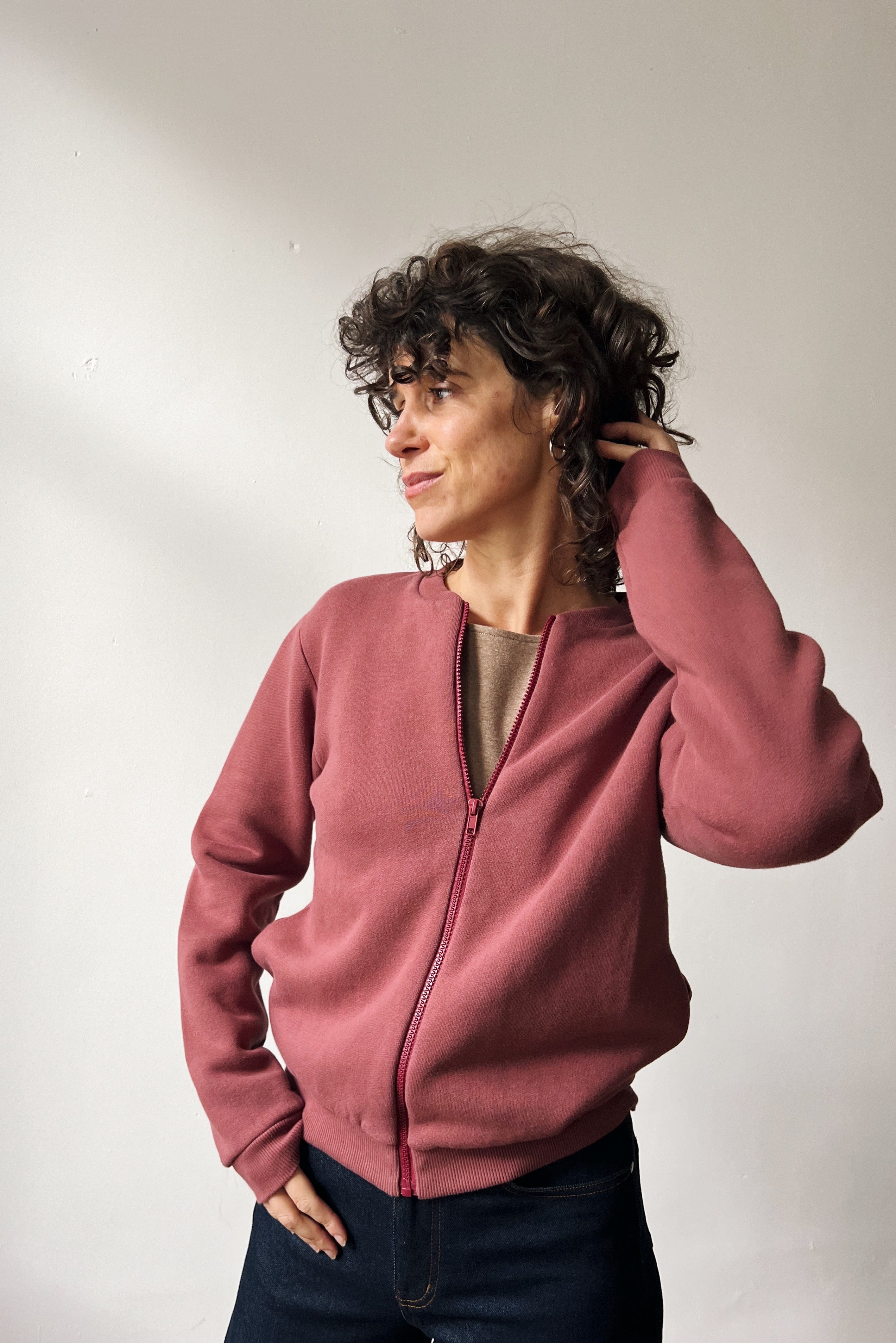 Person wearing a figue zip-up sweatshirt against a plain background