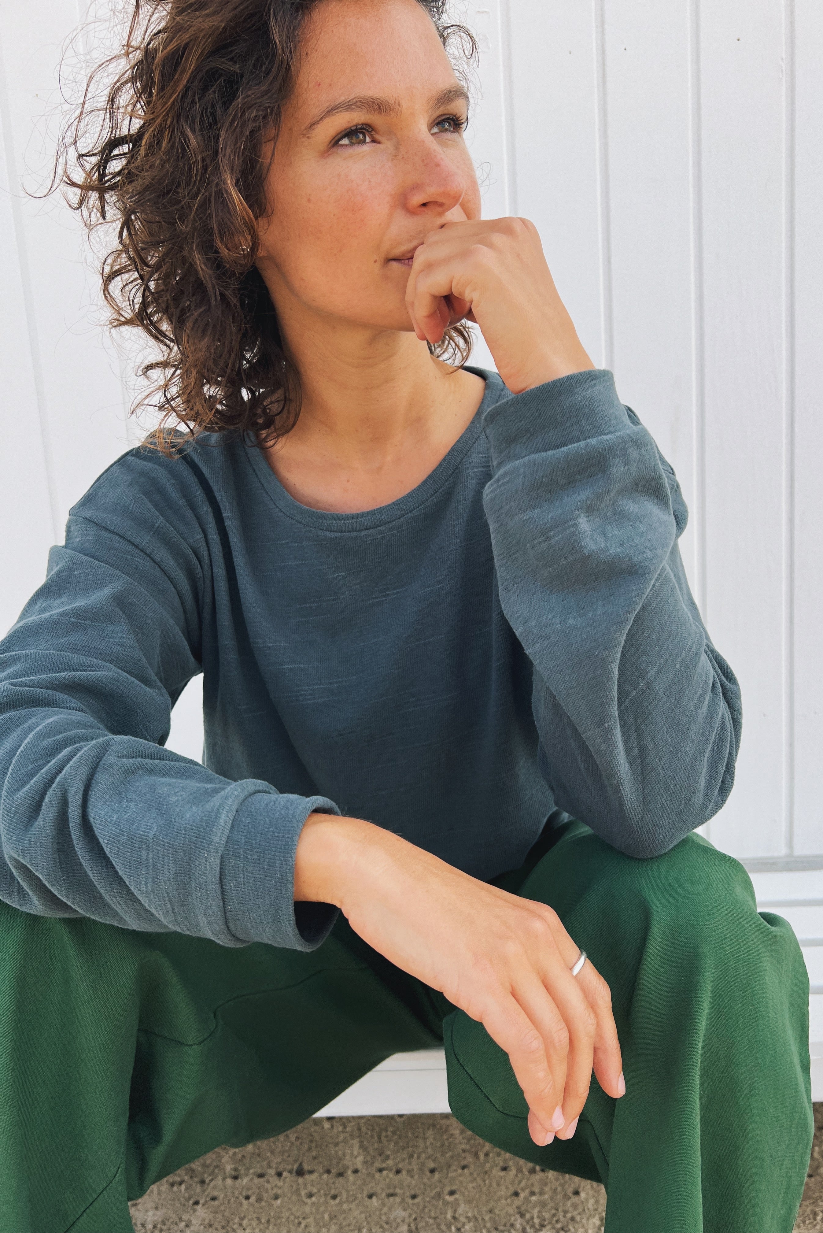 A sweatshirt made of soft knitted fabric. It has long sleeves, dropped shoulders, a round neckline, and ribbed cuffs. This sweatshirt has a straight fit.