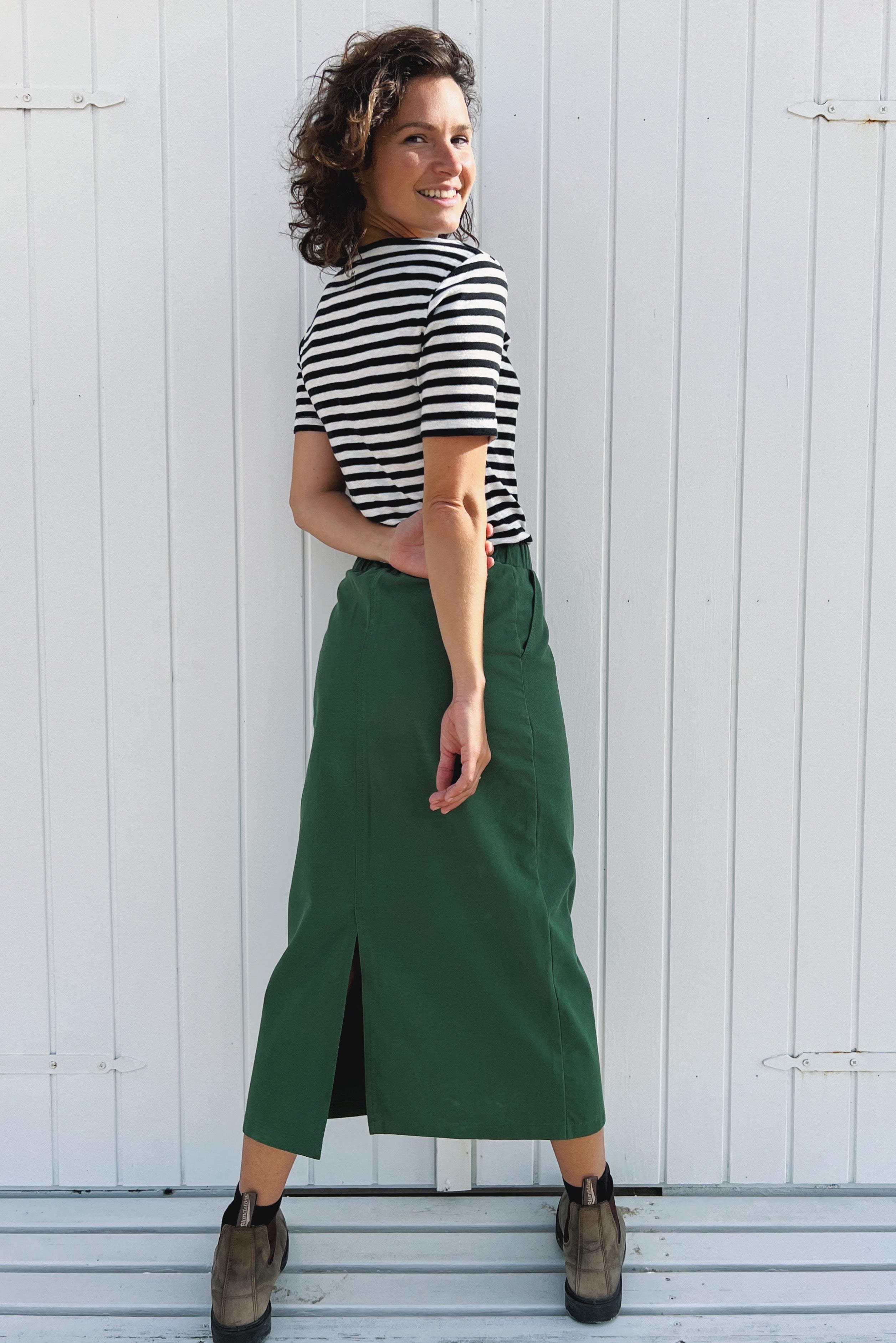 Midi skirt with a straight fit and elastic waistband. The side zipper and back slit ensure a seamless and smooth fit.