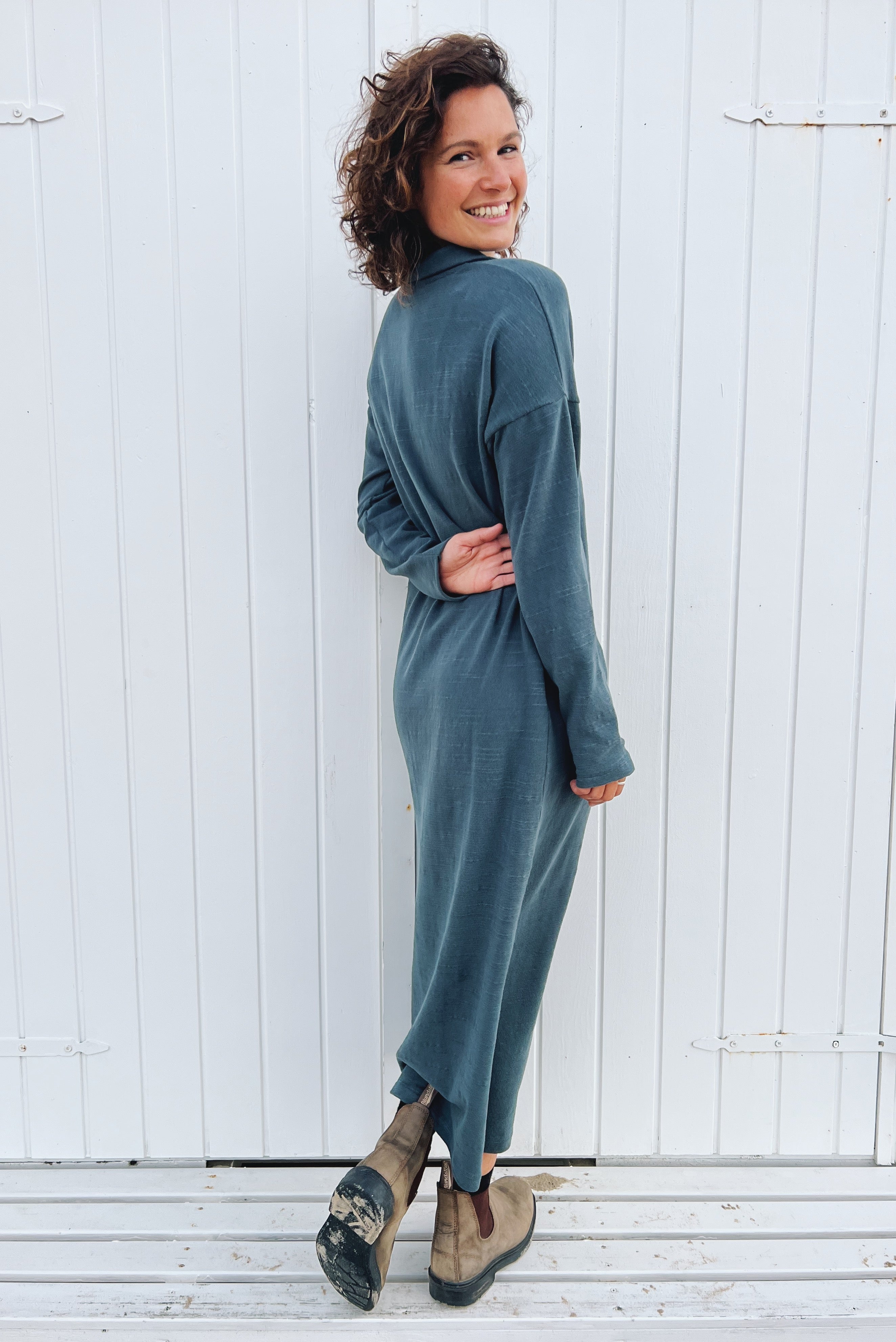 Long dress with long sleeves and a side slit in soft knitted fabric. The collar is finished with a  buttonless V-neckline and a collar design.