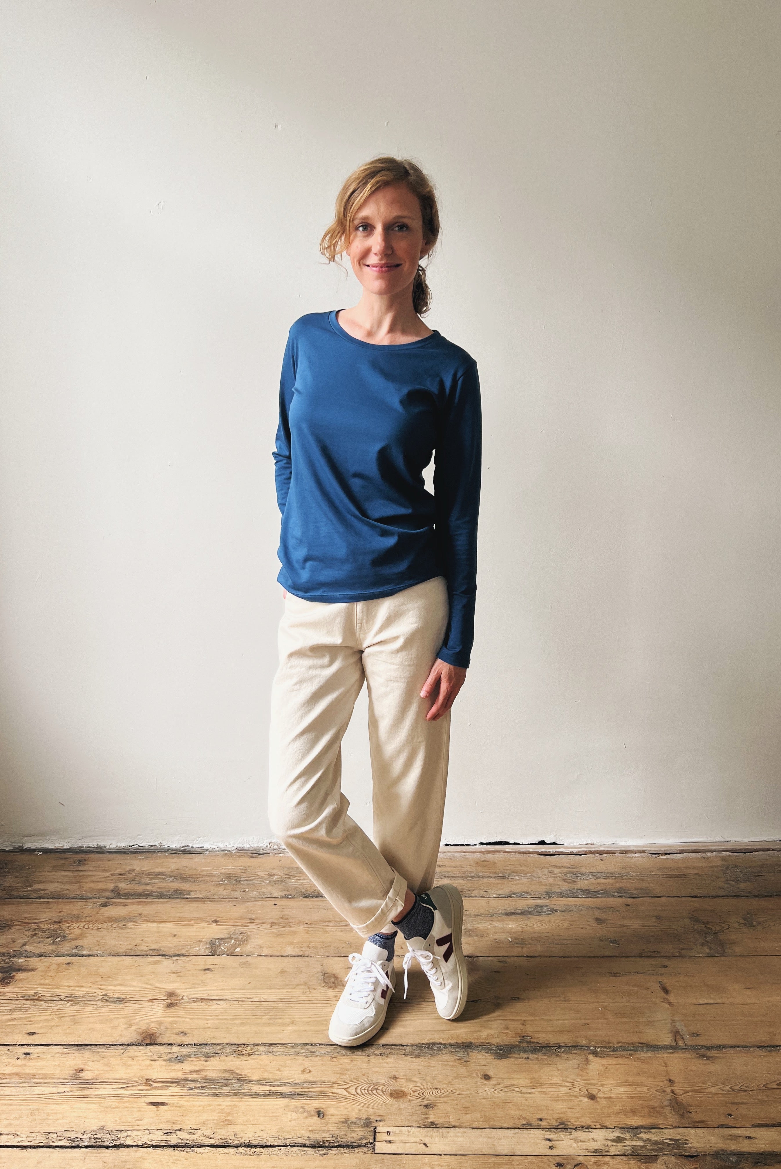 Person wearing a blue sweater and oat boyfriend jeans